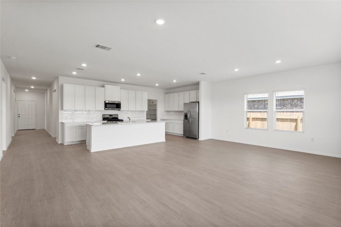 Empty room, Interior, Kitchen, Recessed Lighting, Stainless Steel Appliances, Wood Texture Flooring