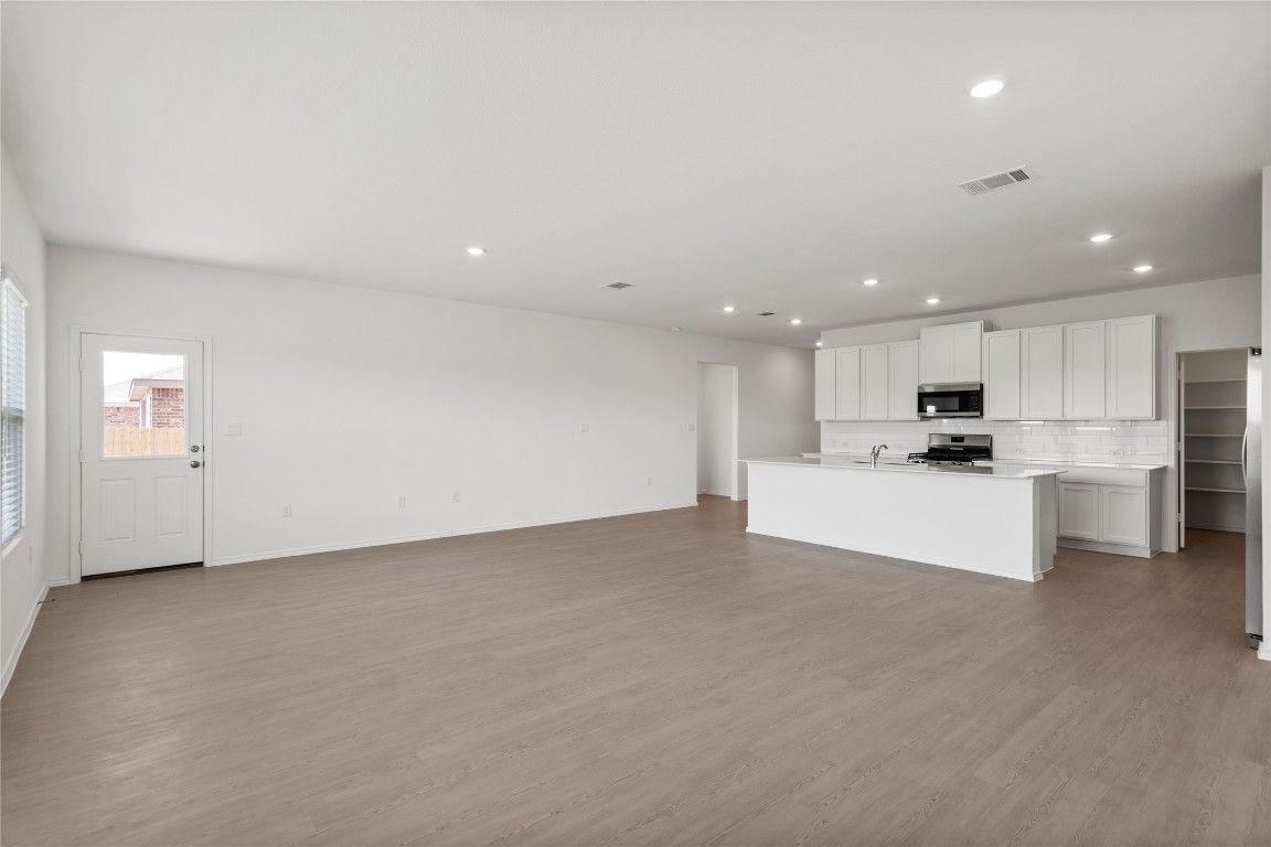 Empty room, Interior, Kitchen, Recessed Lighting, Stainless Steel Appliances, Wood Texture Flooring