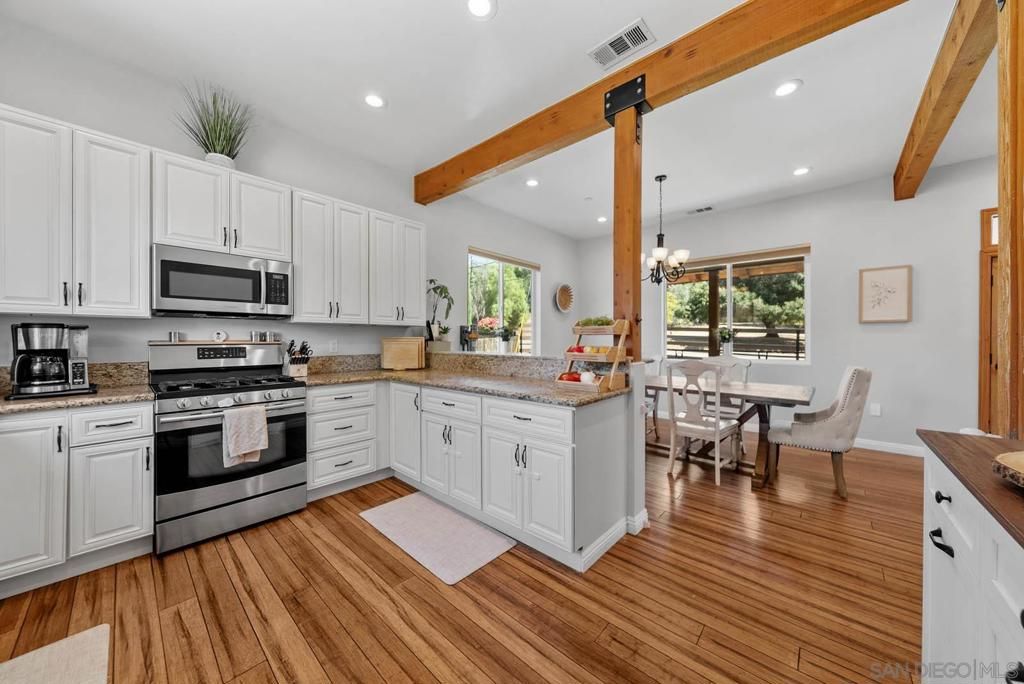Chandelier, Dining room, Interior, Kitchen, Recessed Lighting, Stainless Steel Appliances, Wooden Beams, Wood Texture Flooring