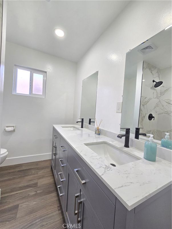 Bathroom, Dual Sink Vanities, Interior, Marble Walls, Recessed Lighting, Wood Texture Flooring