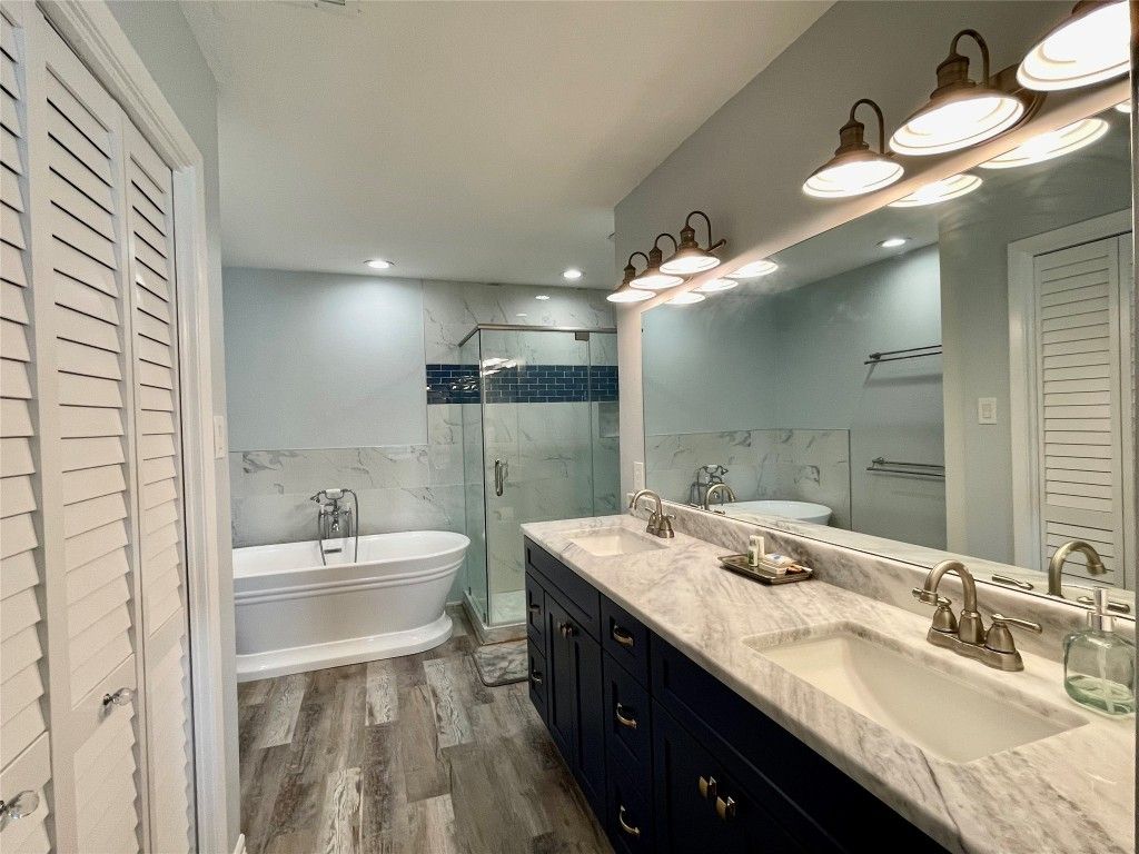 Bathroom, Dual Sink Vanities, Free Standing Baths, Glass Shower, Interior, Marble Walls, Recessed Lighting, Wood Texture Flooring