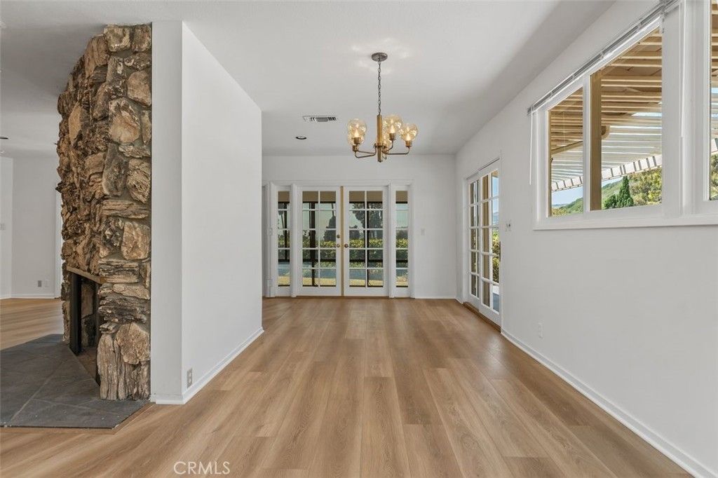 Chandelier, Empty room, Fireplace, Interior, Recessed Lighting, Stone Walls, Wood Texture Flooring
