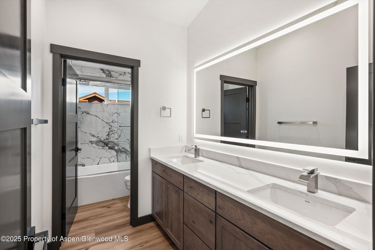 Bathroom, Dual Sink Vanities, Glass Shower, Interior, Marble Walls, Wood Texture Flooring