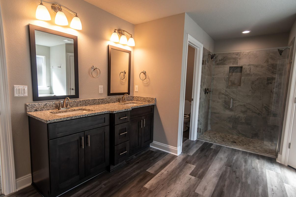 Bathroom, Dual Sink Vanities, Glass Shower, Interior, Marble Walls, Recessed Lighting, Wood Texture Flooring