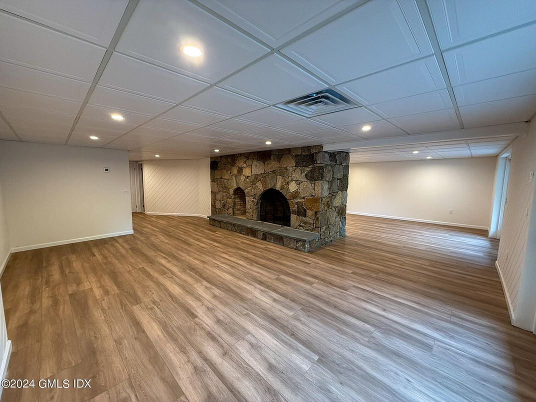Empty room, Fireplace, Interior, Recessed Lighting, Stone Walls, Wood Texture Flooring