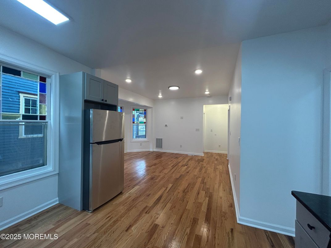 Empty room, Interior, Kitchen, Recessed Lighting, Stainless Steel Appliances, Wood Texture Flooring