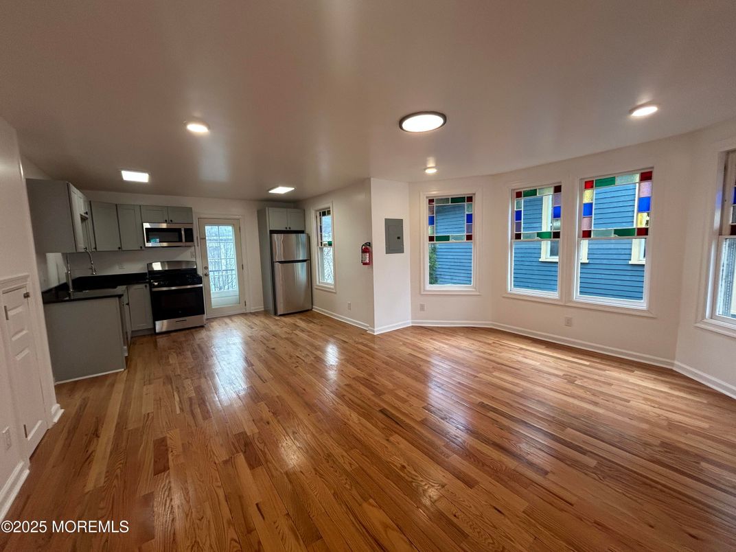 Empty room, Interior, Kitchen, Recessed Lighting, Stainless Steel Appliances, Wood Texture Flooring