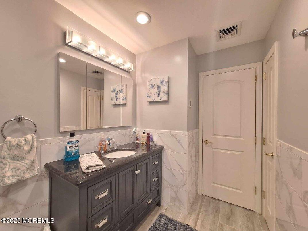 Bathroom, Dual Sink Vanities, Interior, Marble Walls, Recessed Lighting, Wood Texture Flooring
