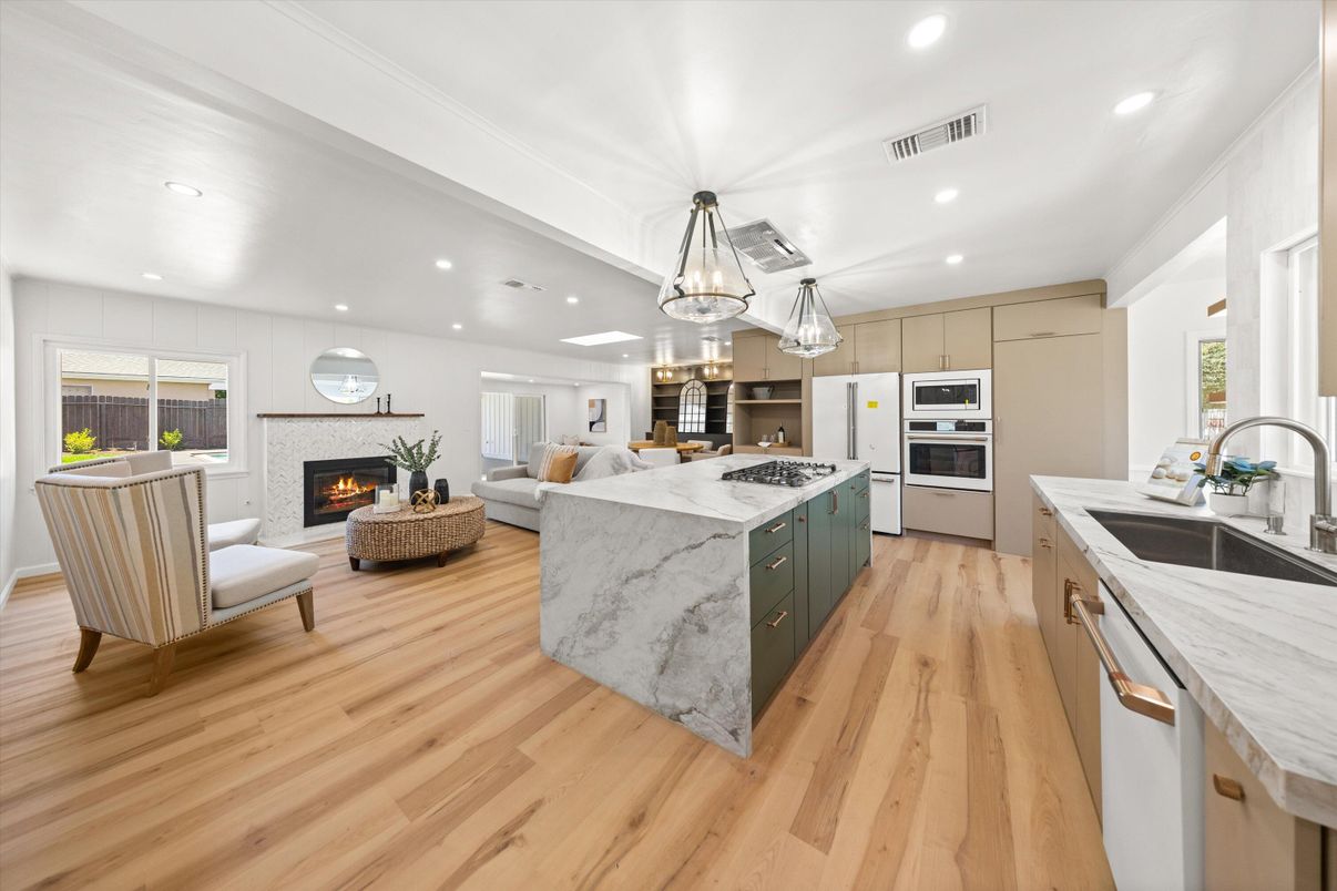 Chandelier, Fireplace, Interior, Kitchen, Living room, Pendant Lights, Recessed Lighting, Stainless Steel Appliances, Wood Texture Flooring