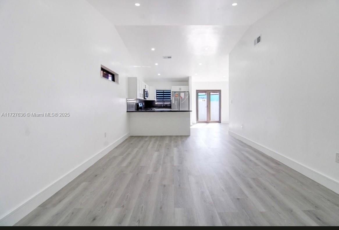 Empty room, Interior, Kitchen, Recessed Lighting, Stainless Steel Appliances, Wood Texture Flooring