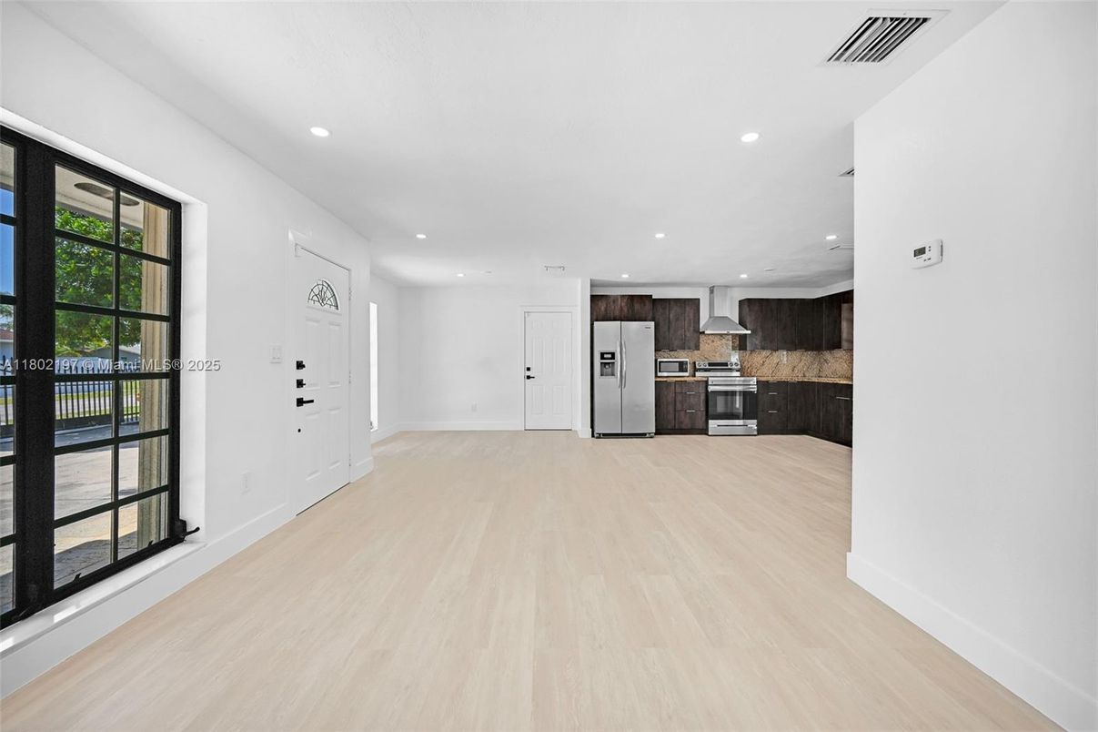 Empty room, Interior, Kitchen, Recessed Lighting, Stainless Steel Appliances, Wood Texture Flooring
