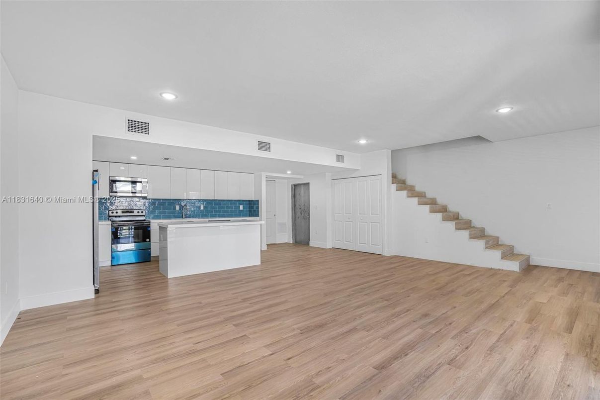 Empty room, Interior, Kitchen, Recessed Lighting, Stainless Steel Appliances, Wood Texture Flooring