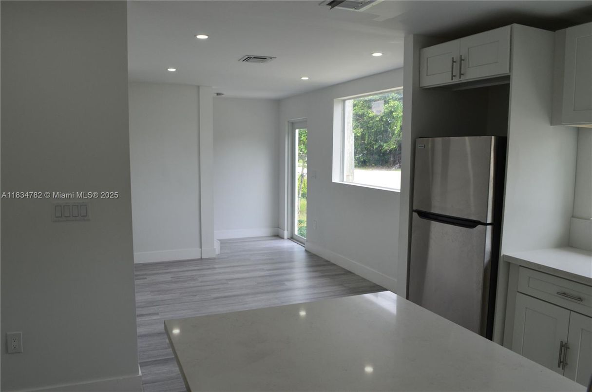 Empty room, Interior, Kitchen, Recessed Lighting, Stainless Steel Appliances, Wood Texture Flooring