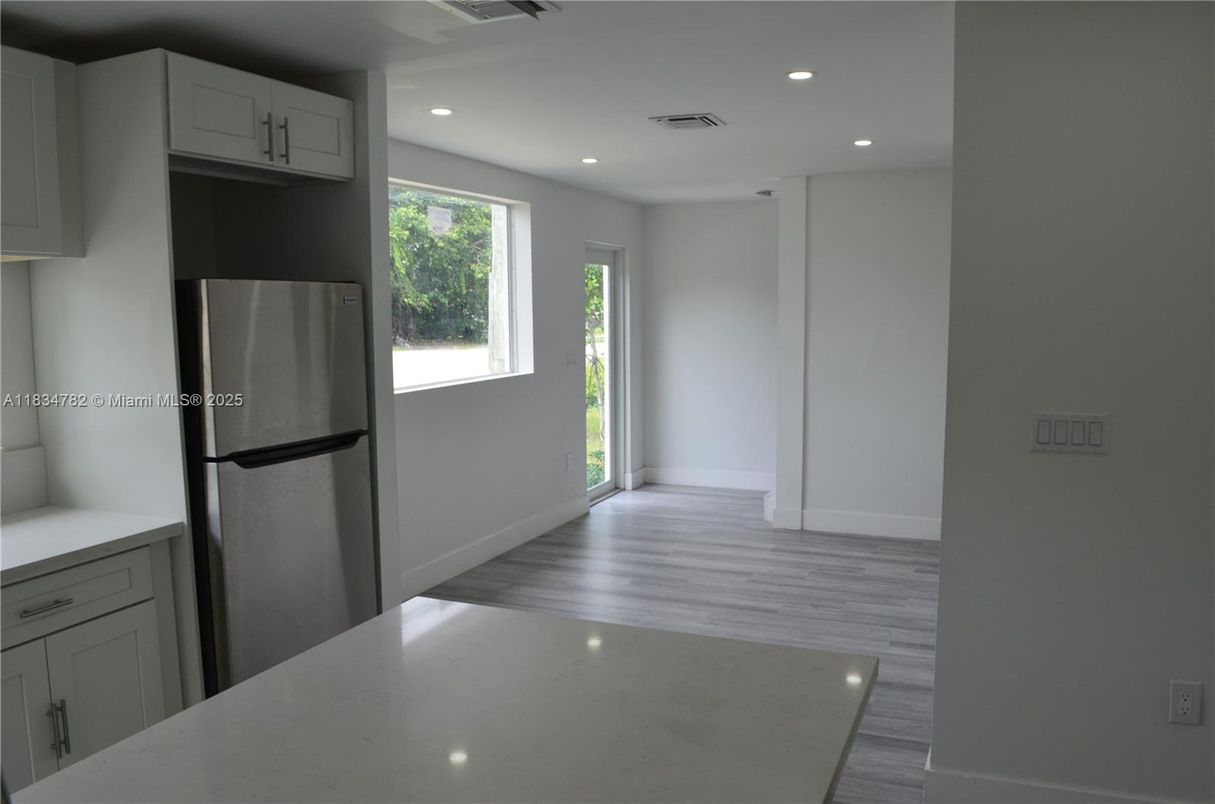 Empty room, Interior, Kitchen, Recessed Lighting, Stainless Steel Appliances, Wood Texture Flooring