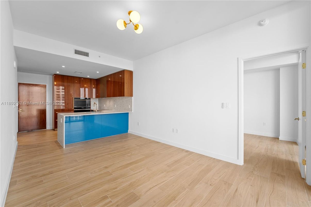 Empty room, Interior, Kitchen, Recessed Lighting, Stainless Steel Appliances, Wood Texture Flooring