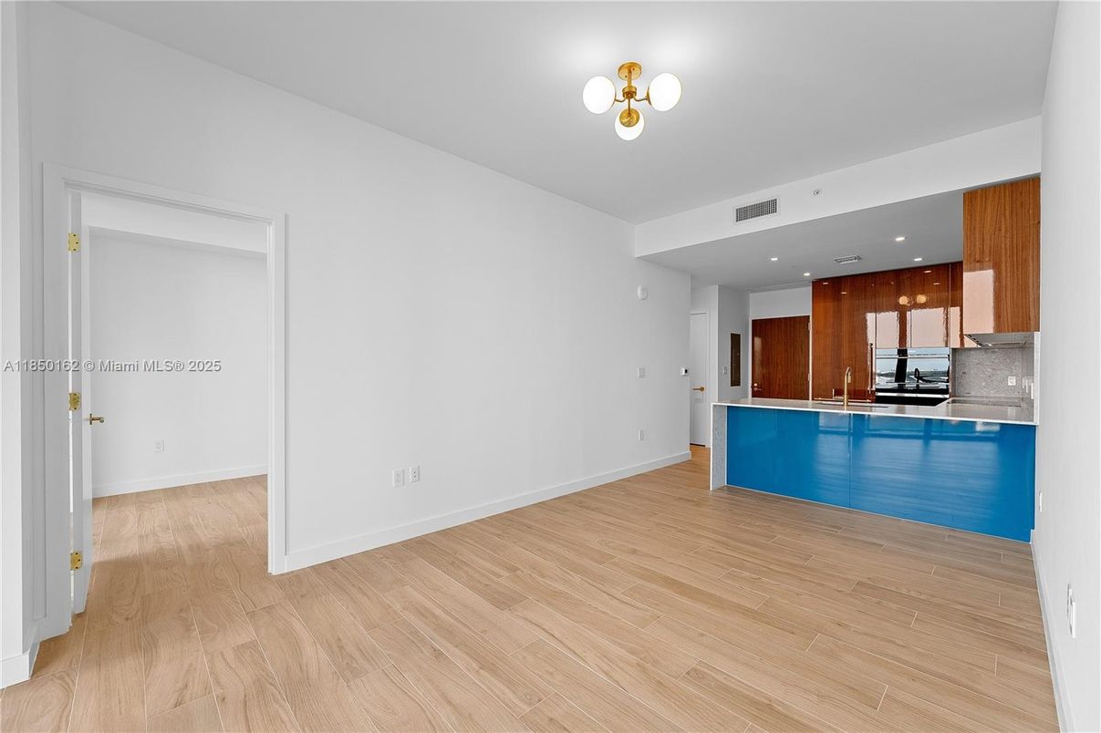 Empty room, Interior, Kitchen, Recessed Lighting, Stainless Steel Appliances, Wood Texture Flooring