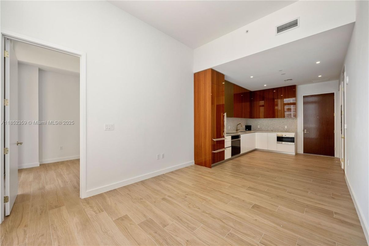 Empty room, Interior, Kitchen, Recessed Lighting, Stainless Steel Appliances, Wood Texture Flooring