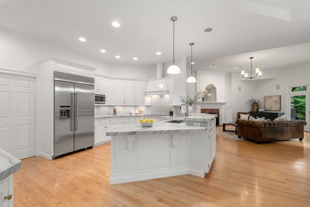 Chandelier, Fireplace, Interior, Kitchen, Living room, Pendant Lights, Recessed Lighting, Stainless Steel Appliances, Wood Texture Flooring