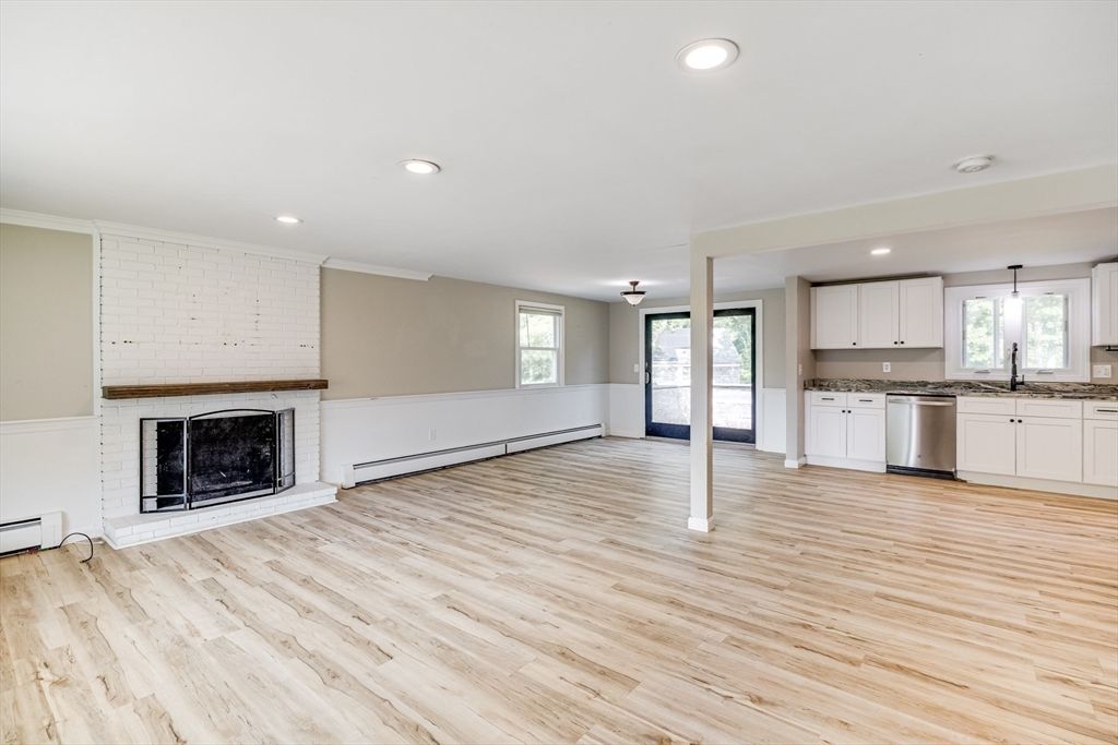 Empty room, Fireplace, Interior, Kitchen, Pendant Lights, Recessed Lighting, Stainless Steel Appliances, Wood Texture Flooring