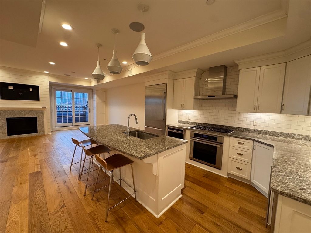 Fireplace, Interior, Kitchen, Pendant Lights, Recessed Lighting, Stainless Steel Appliances, Wood Texture Flooring