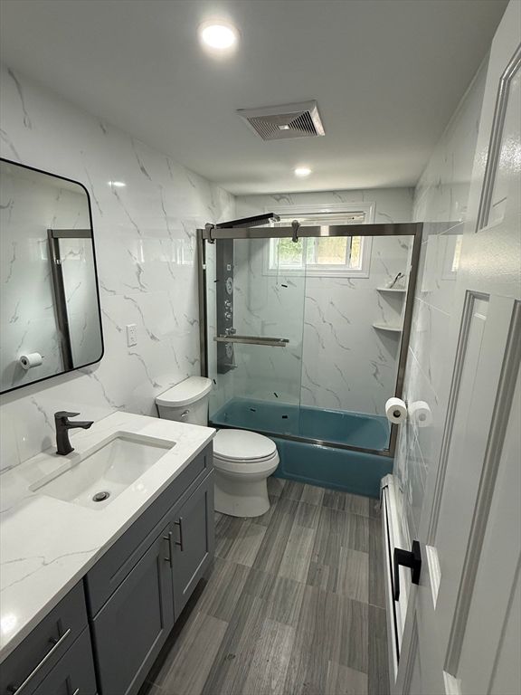 Bathroom, Dual Sink Vanities, Glass Shower, Interior, Marble Walls, Recessed Lighting, Wood Texture Flooring