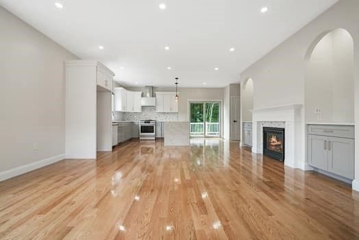 Empty room, Fireplace, Interior, Kitchen, Pendant Lights, Recessed Lighting, Stainless Steel Appliances, Wood Texture Flooring