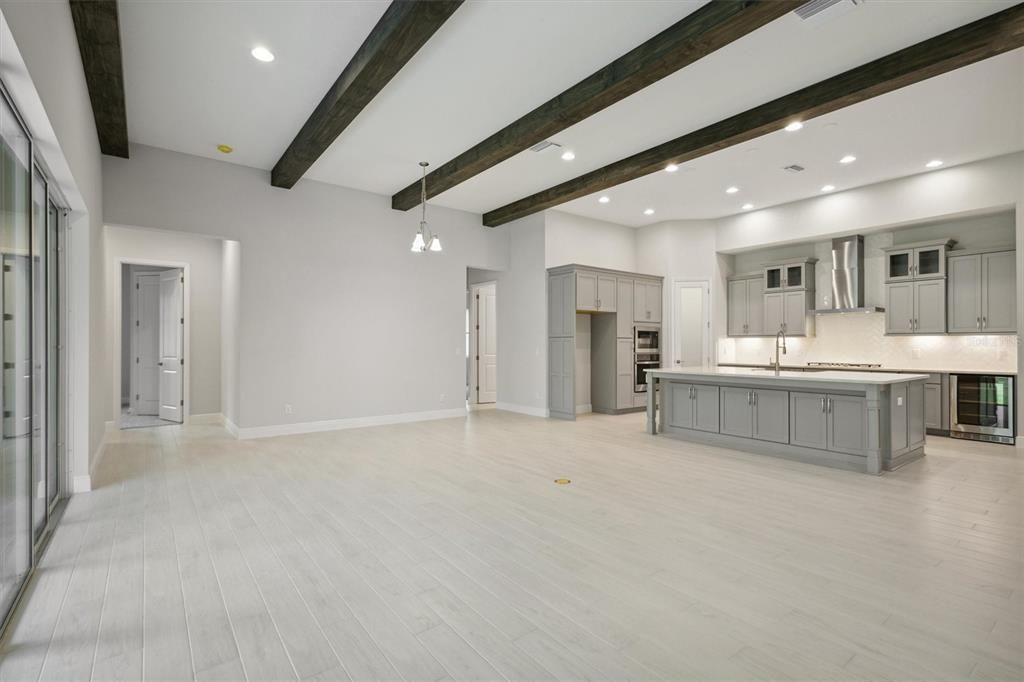 Empty room, Interior, Kitchen, Pendant Lights, Recessed Lighting, Stainless Steel Appliances, Wooden Beams, Wood Texture Flooring
