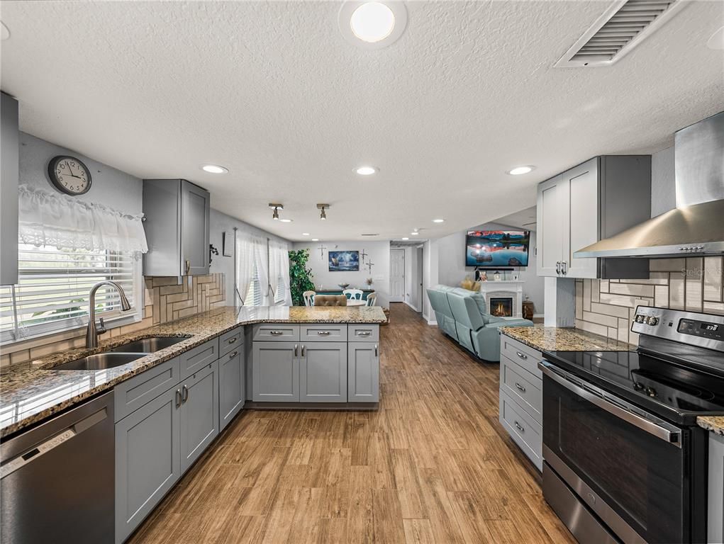 Fireplace, Interior, Kitchen, Living room, Recessed Lighting, Stainless Steel Appliances, Wood Texture Flooring