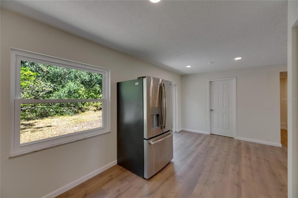 Empty room, Interior, Kitchen, Recessed Lighting, Stainless Steel Appliances, Wood Texture Flooring
