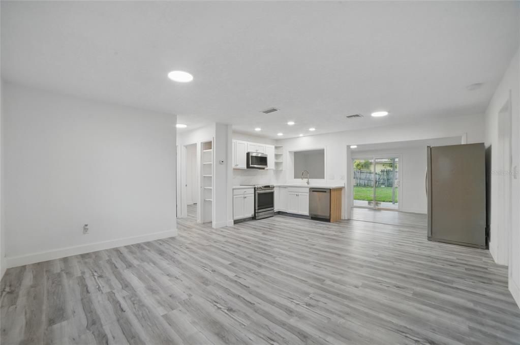 Empty room, Interior, Kitchen, Recessed Lighting, Stainless Steel Appliances, Wood Texture Flooring