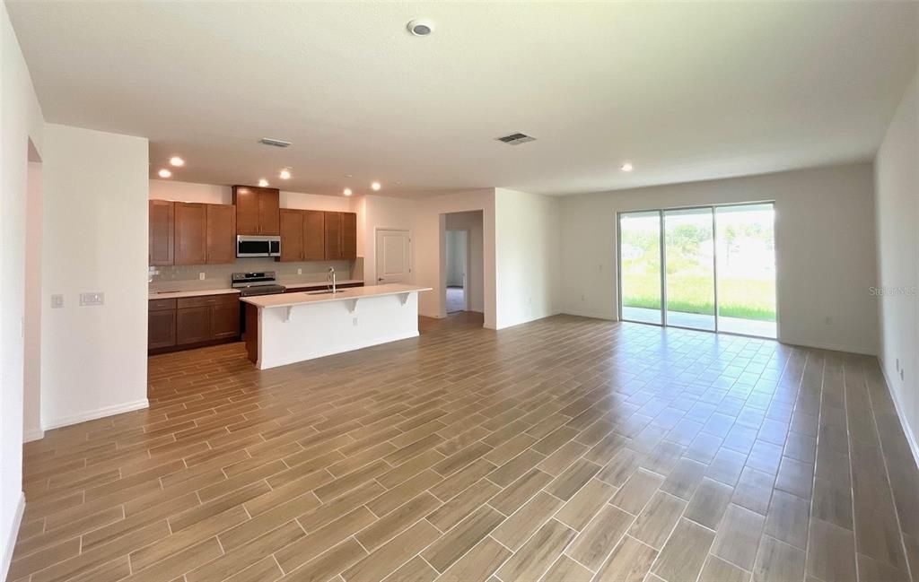 Empty room, Interior, Kitchen, Recessed Lighting, Stainless Steel Appliances, Wood Texture Flooring