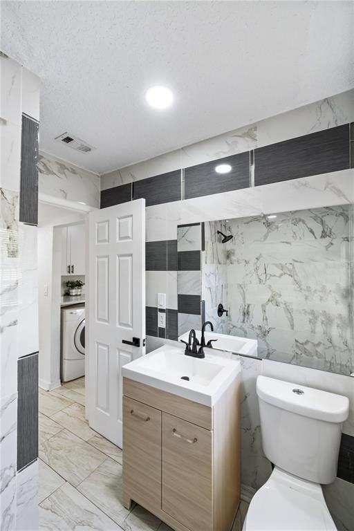 Bathroom, Dual Sink Vanities, Interior, Marble, Marble Walls, Recessed Lighting, Utility Closets, Washer