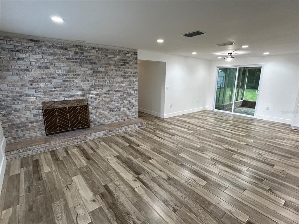 Empty room, Fireplace, Interior, Recessed Lighting, Stone Walls, Wood Texture Flooring