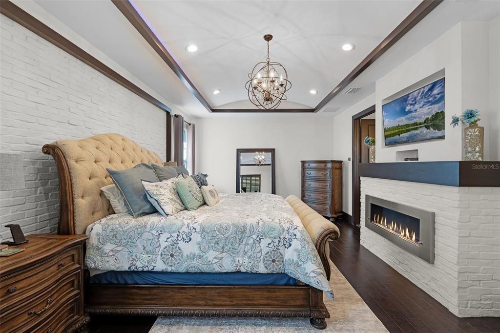 Bedroom, Chandelier, Fireplace, Interior, Recessed Lighting, Stone Walls, Wood Texture Flooring