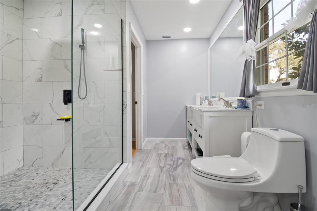 Bathroom, Dual Sink Vanities, Glass Shower, Interior, Marble Walls, Recessed Lighting, Wood Texture Flooring