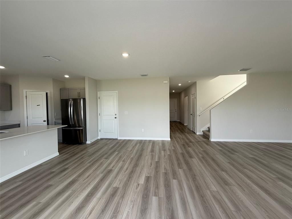 Empty room, Interior, Kitchen, Recessed Lighting, Stainless Steel Appliances, Wood Texture Flooring