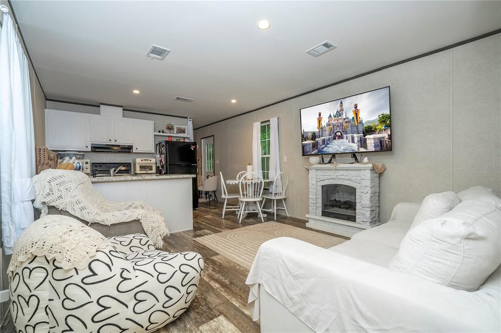 Dining room, Fireplace, Interior, Kitchen, Living room, Recessed Lighting, Stainless Steel Appliances, Wood Texture Flooring