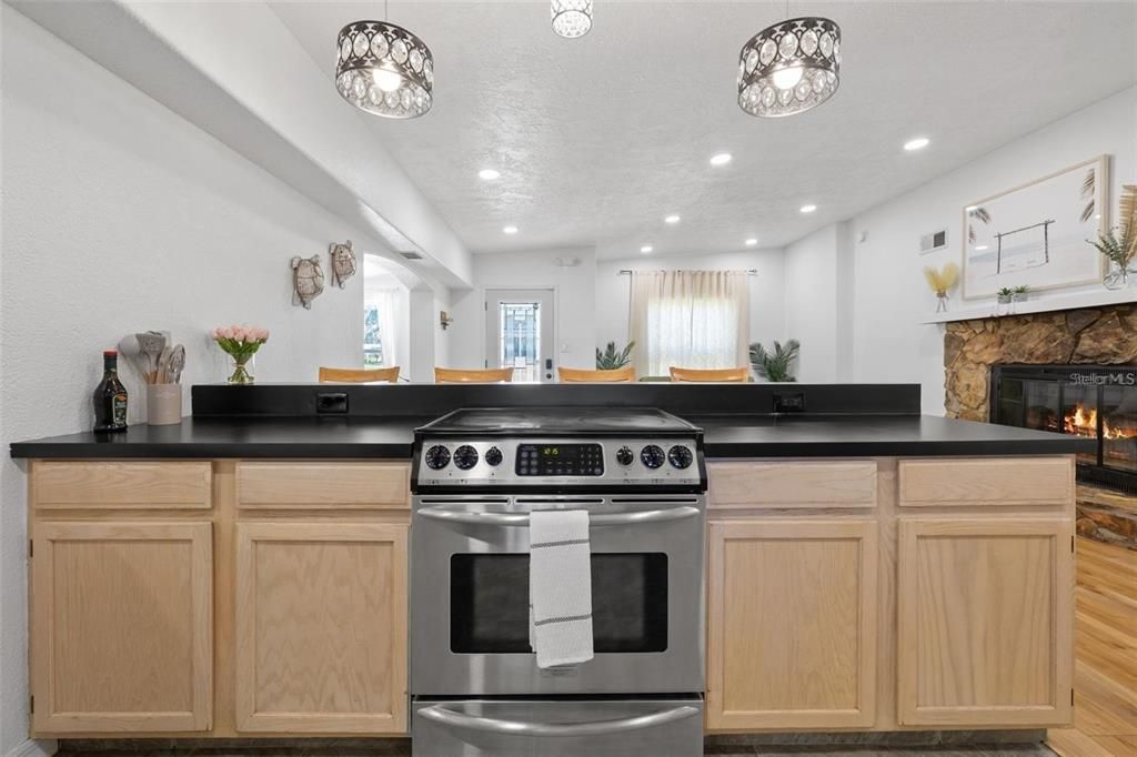 Fireplace, Interior, Kitchen, Recessed Lighting, Stainless Steel Appliances, Wood Texture Flooring