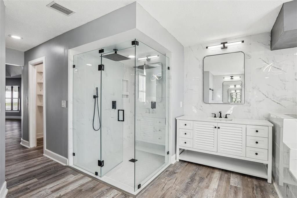 Bathroom, Dual Sink Vanities, Glass Shower, Interior, Marble Walls, Recessed Lighting, Wood Texture Flooring