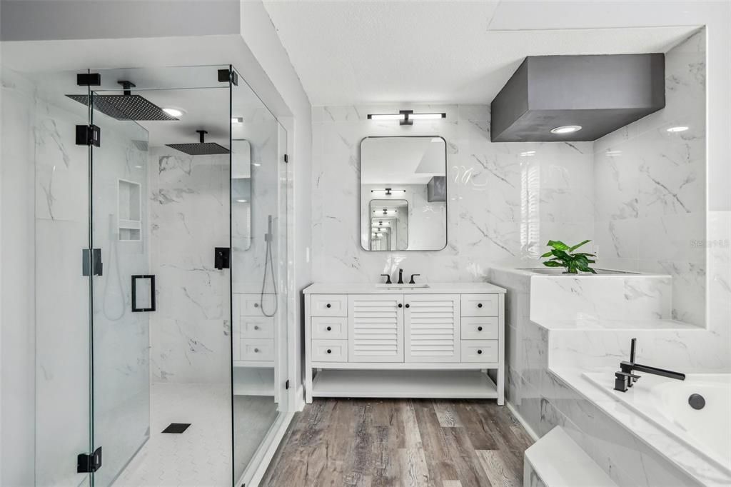 Bathroom, Dual Sink Vanities, Glass Shower, Interior, Marble Walls, Recessed Lighting, Wood Texture Flooring