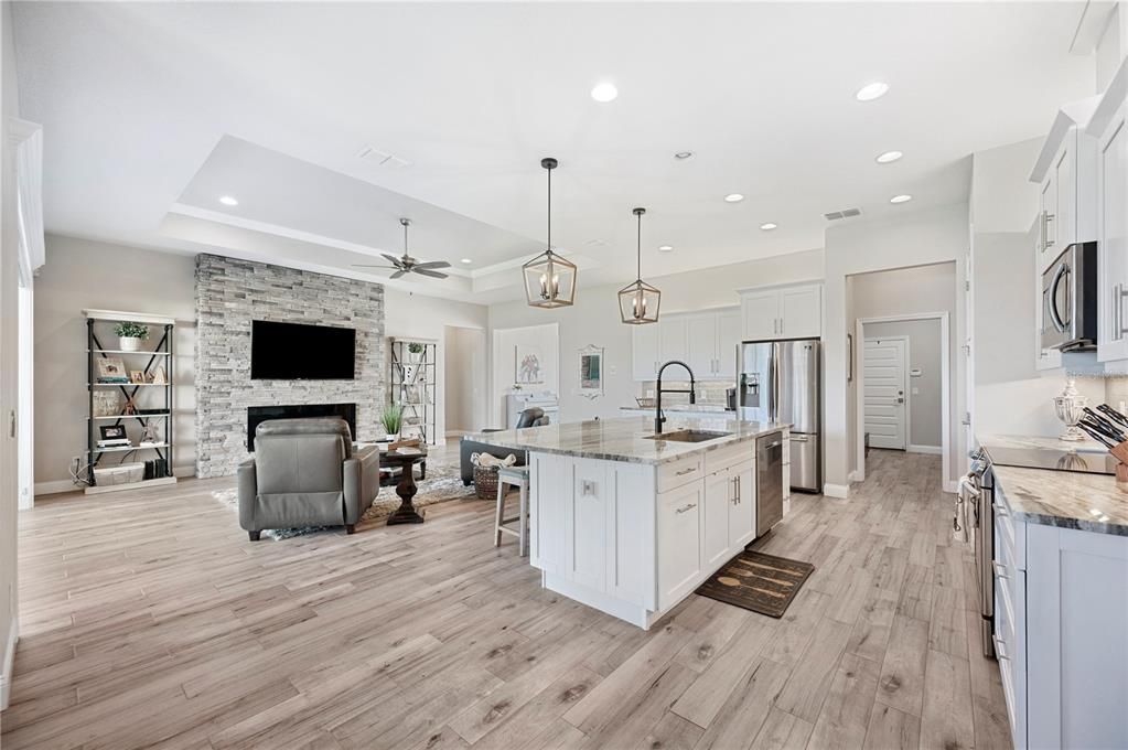 Fireplace, Interior, Kitchen, Pendant Lights, Recessed Lighting, Stainless Steel Appliances, Stone Walls, Wood Texture Flooring