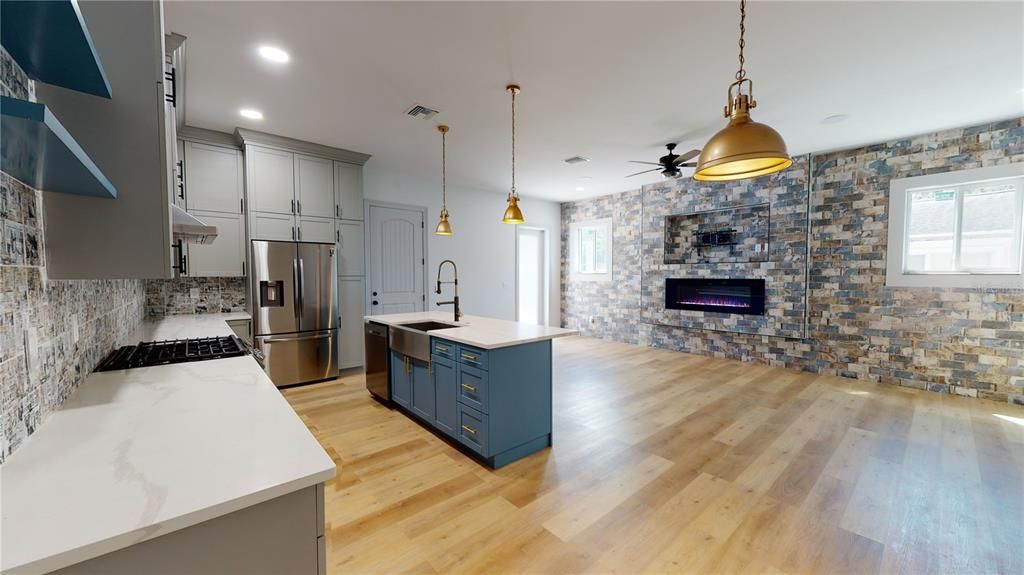 Fireplace, Interior, Kitchen, Pendant Lights, Recessed Lighting, Stainless Steel Appliances, Stone Walls, Wood Texture Flooring