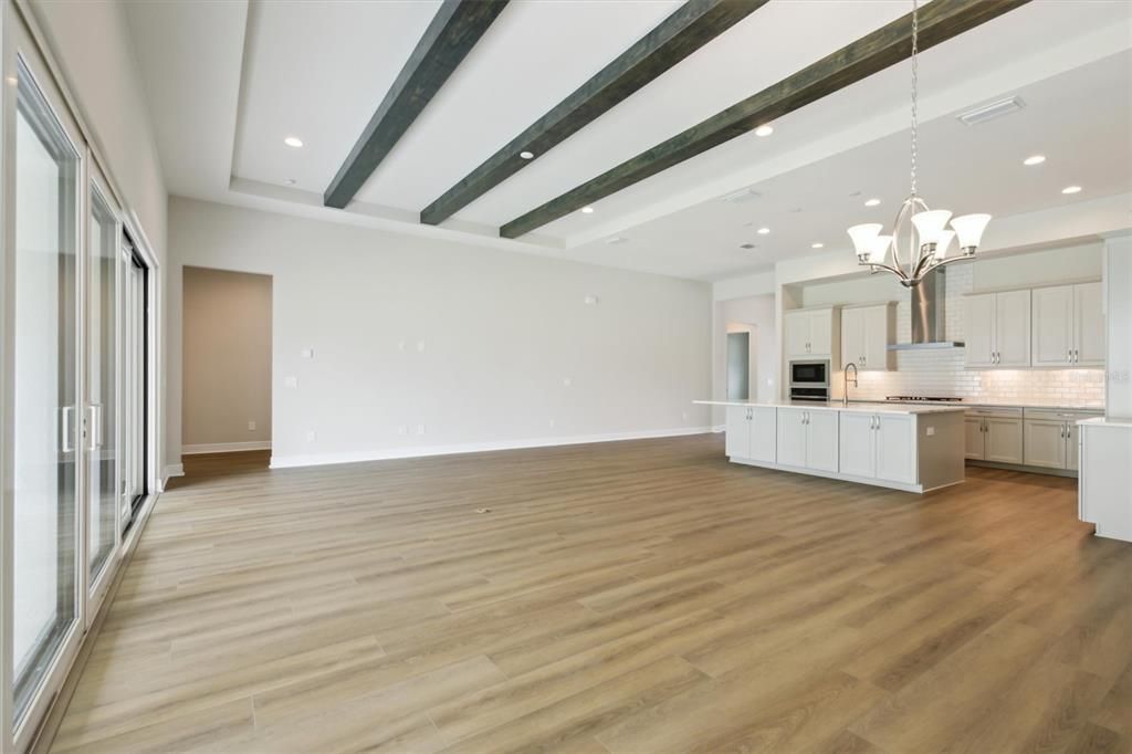 Chandelier, Empty room, Interior, Kitchen, Recessed Lighting, Stainless Steel Appliances, Wooden Beams, Wood Texture Flooring