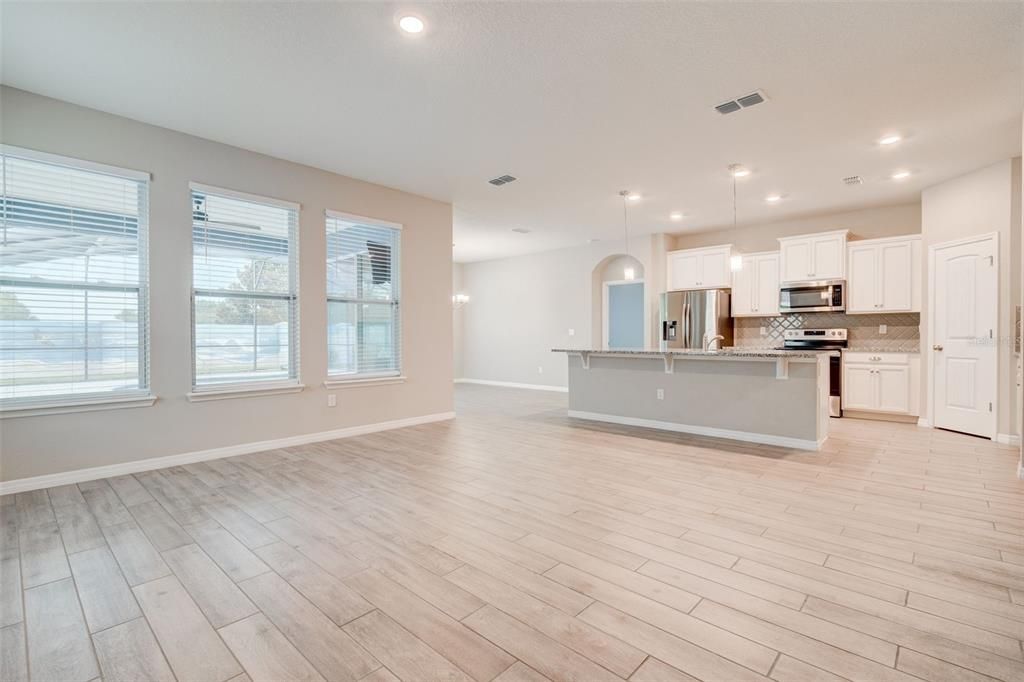Empty room, Interior, Kitchen, Pendant Lights, Recessed Lighting, Stainless Steel Appliances, Wood Texture Flooring