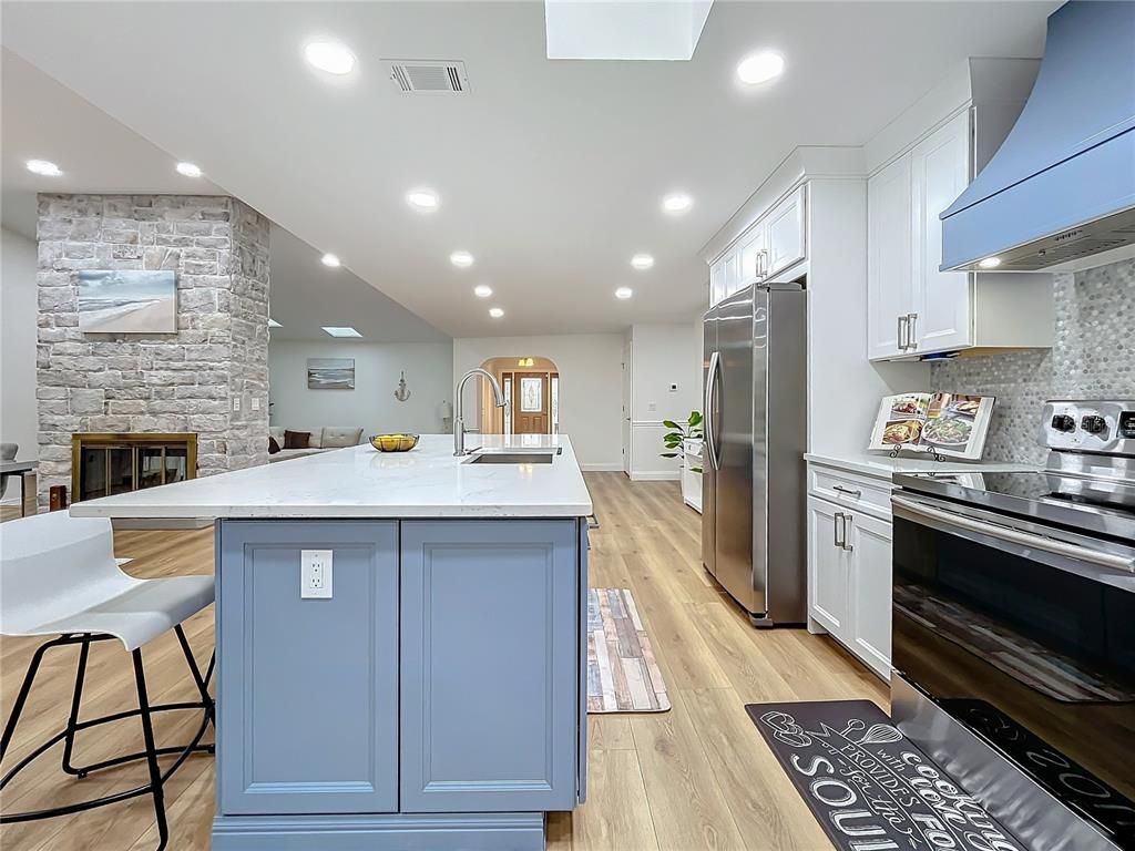 Fireplace, Interior, Kitchen, Recessed Lighting, Stainless Steel Appliances, Stone Walls, Wood Texture Flooring