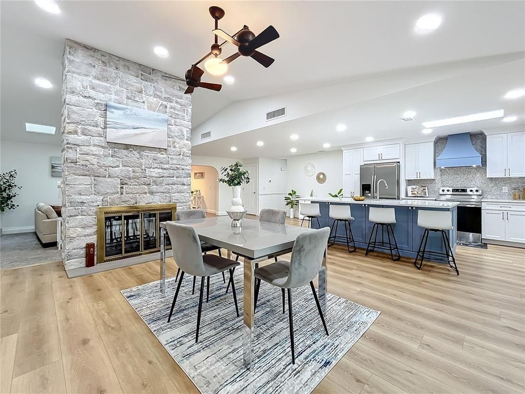 Dining room, Fireplace, Interior, Kitchen, Recessed Lighting, Stainless Steel Appliances, Stone Walls, Wood Texture Flooring