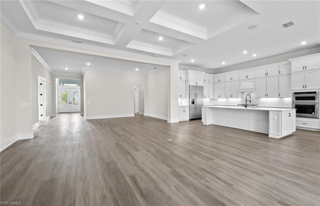 Empty room, Interior, Kitchen, Recessed Lighting, Stainless Steel Appliances, Wood Texture Flooring