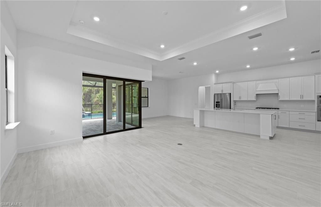 Empty room, Interior, Kitchen, Recessed Lighting, Stainless Steel Appliances, Wood Texture Flooring