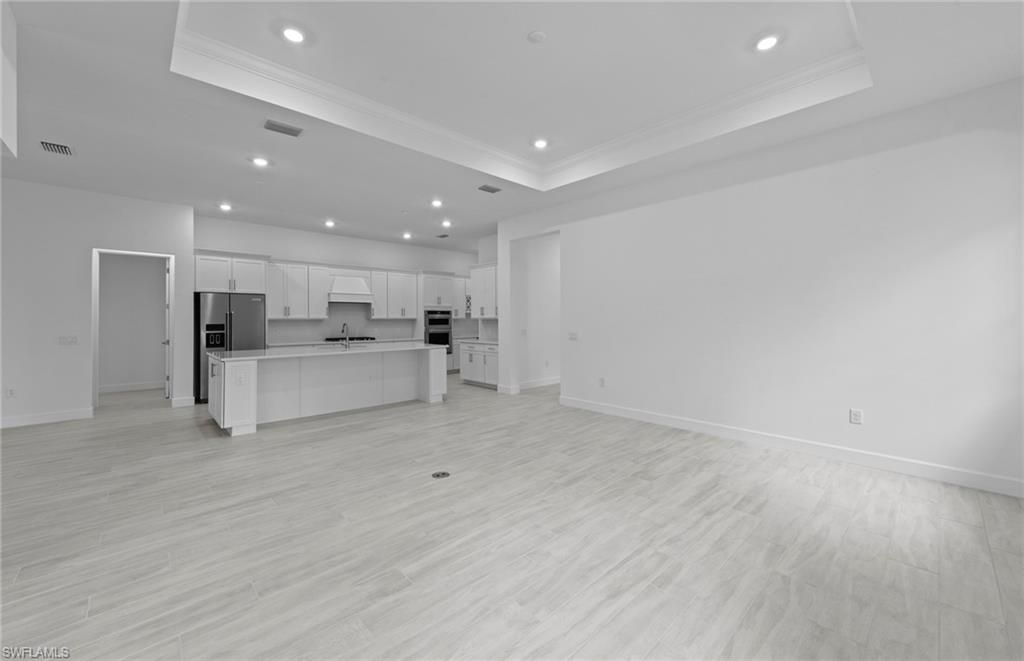 Empty room, Interior, Kitchen, Recessed Lighting, Stainless Steel Appliances, Wood Texture Flooring