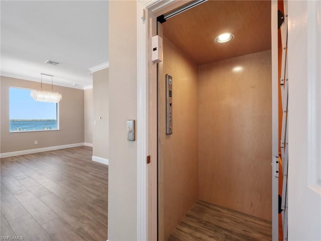 Chandelier, Elevator, Interior, Recessed Lighting, Wood Texture Flooring, Wooden Walls